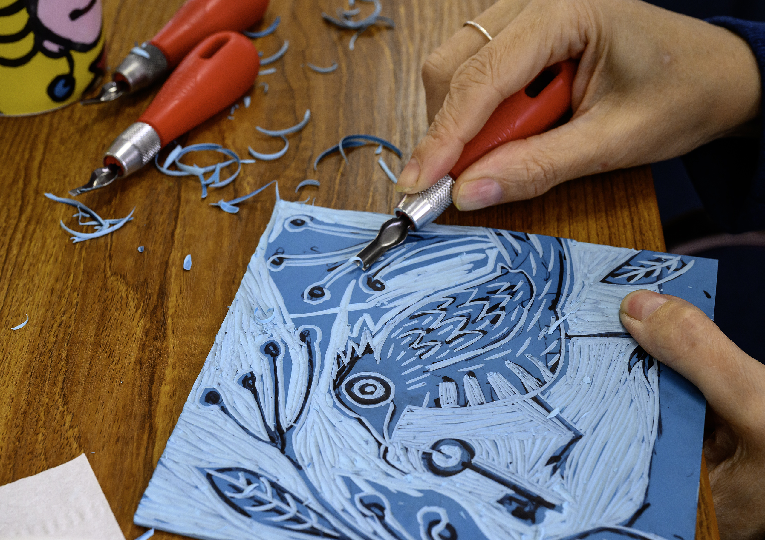 Image shows delegate carefully cutting the lino on the Lino Printing workshop from Photoartcollections